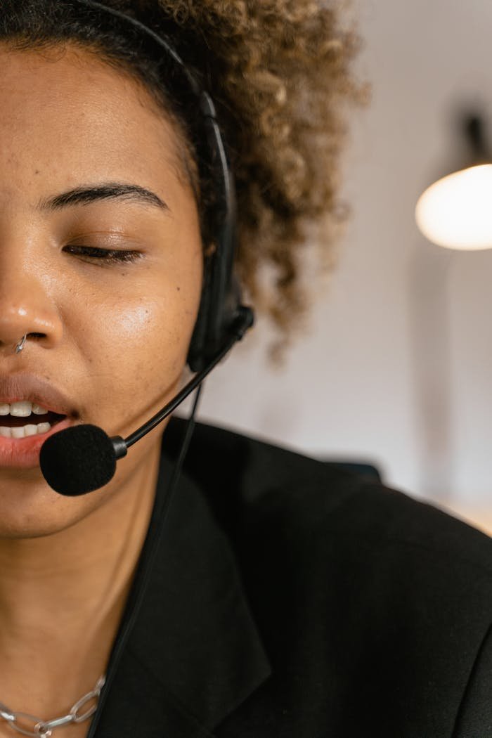 Close-up of a woman wearing a headset, engaged in customer support, working in an office.